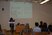 Abgebildet ist Frau Mag. Dr. Rosemarie Felder-Puig vom Ludwig Boltzmann Institut Health Promotion Research. Sie trägt eine schwarze Hose, einen schwarzen Blazer und einen hell gemusterten Schal. Sie steht vor dem Rednerpult, dahinter an der Wand eine Powerpoint-Präsentation